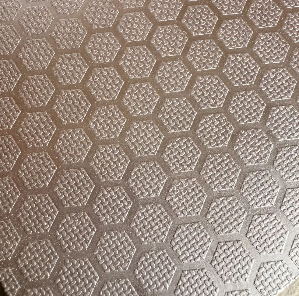 Close view of raised hexagonal honeycomb embossing on a brown anti-slip plywood face